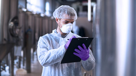A man in a lab coat holding a clipboard 