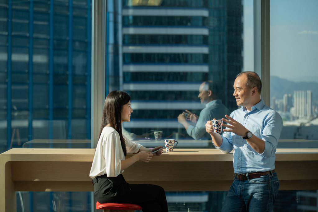 Un homme et une femme assis à une table devant une fenêtre 