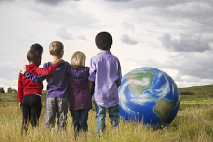 a group of children standing together looking at an image of the earth