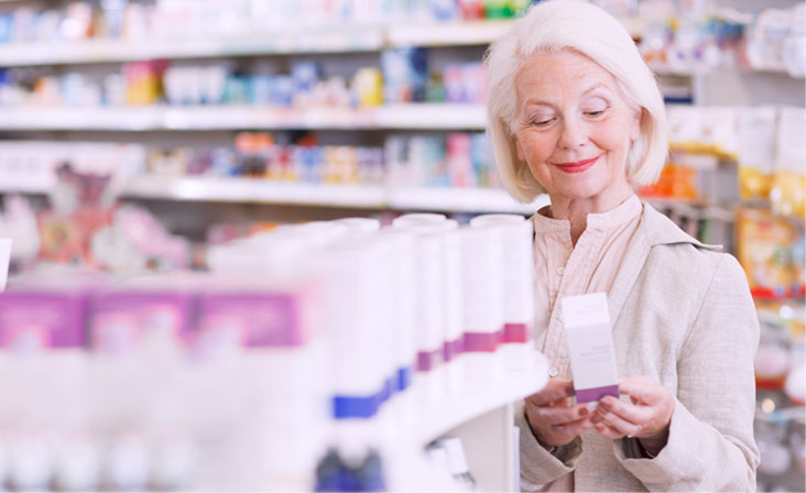 A woman is looking at medicine in a store